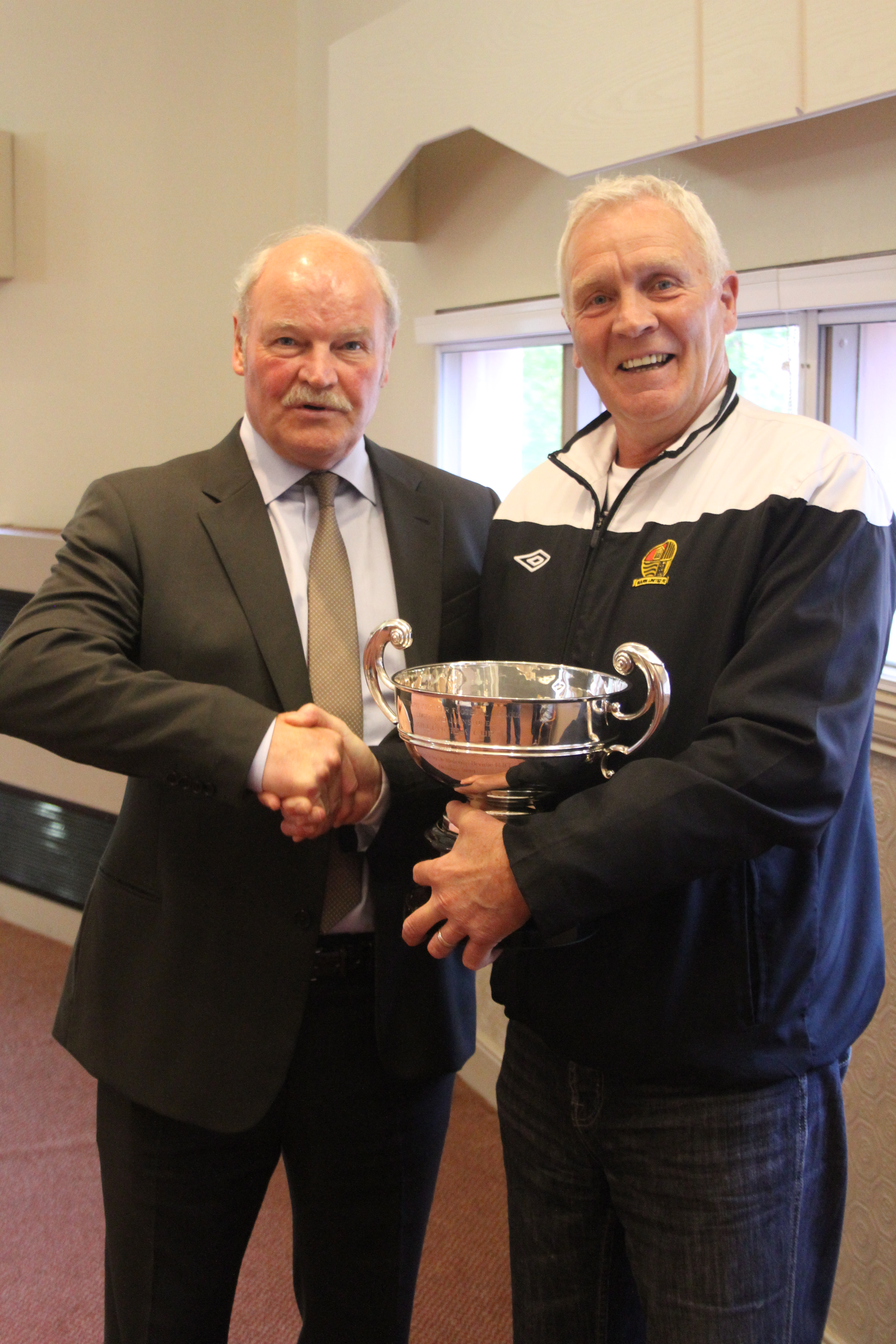 Brian White of Barn Utd being presented with the Logan/Johnstone Cup M Brodie merit award by guest speaker Ronnir McFall